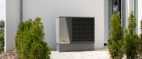 Modern heat pump unit beside a residential home