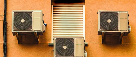 Mini-split air conditioning condenser units mounted on a building wall