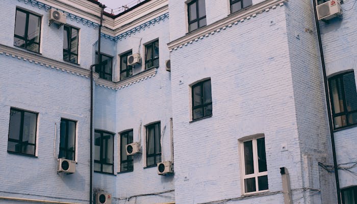 Apartment building exterior with multiple air conditioning units on the walls