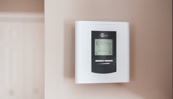 Digital thermostat mounted on a residential wall for home climate control